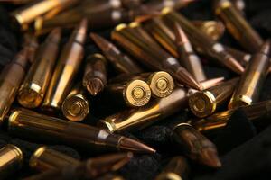 Cartridges for automatic carbine caliber .223 on charcoal. Ammunition for automatic and semi-automatic rifles. Dark back. photo