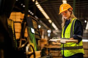 Factory engineer woman standing confident to control panel switch. Worker works at heavy machine at industry factory. worker checking timber of raw wood material. smart industry worker operating. photo