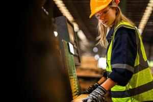 Factory engineer woman standing confident to control panel switch. Worker works at heavy machine at industry factory. worker checking timber of raw wood material. smart industry worker operating. photo