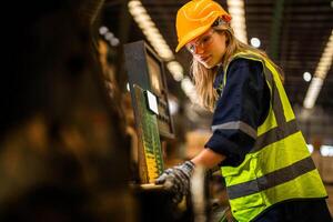 Factory engineer woman standing confident to control panel switch. Worker works at heavy machine at industry factory. worker checking timber of raw wood material. smart industry worker operating. photo