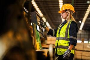 Factory engineer woman standing confident to control panel switch. Worker works at heavy machine at industry factory. worker checking timber of raw wood material. smart industry worker operating. photo