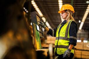 Factory engineer woman standing confident to control panel switch. Worker works at heavy machine at industry factory. worker checking timber of raw wood material. smart industry worker operating. photo