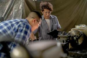 Men are inspecting steel parts for machine installation. team of teacher and student are learning to use heavy machines in steel factory. workers cooperate while doing quality control of manufactured. photo