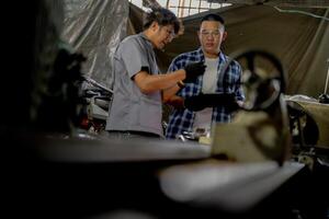 Men are inspecting steel parts for machine installation. team of teacher and student are learning to use heavy machines in steel factory. workers cooperate while doing quality control of manufactured. photo
