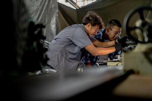 Men are inspecting steel parts for machine installation. team of teacher and student are learning to use heavy machines in steel factory. workers cooperate while doing quality control of manufactured. photo