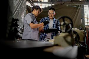 Men are inspecting steel parts for machine installation. team of teacher and student are learning to use heavy machines in steel factory. workers cooperate while doing quality control of manufactured. photo