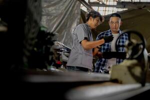 Men are inspecting steel parts for machine installation. team of teacher and student are learning to use heavy machines in steel factory. workers cooperate while doing quality control of manufactured. photo