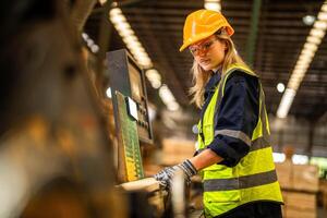 Factory engineer woman standing confident to control panel switch. Worker works at heavy machine at industry factory. worker checking timber of raw wood material. smart industry worker operating. photo