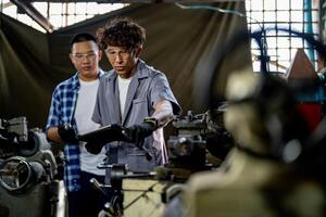 Men are inspecting steel parts for machine installation. team of teacher and student are learning to use heavy machines in steel factory. workers cooperate while doing quality control of manufactured. photo
