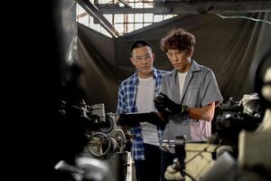 Men are inspecting steel parts for machine installation. team of teacher and student are learning to use heavy machines in steel factory. workers cooperate while doing quality control of manufactured. photo