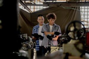Men are inspecting steel parts for machine installation. team of teacher and student are learning to use heavy machines in steel factory. workers cooperate while doing quality control of manufactured. photo