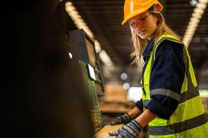 Factory engineer woman standing confident to control panel switch. Worker works at heavy machine at industry factory. worker checking timber of raw wood material. smart industry worker operating. photo