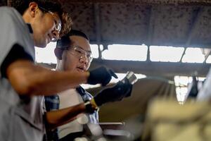 Men are inspecting steel parts for machine installation. team of teacher and student are learning to use heavy machines in steel factory. workers cooperate while doing quality control of manufactured. photo