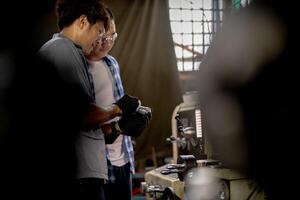 Men are inspecting steel parts for machine installation. team of teacher and student are learning to use heavy machines in steel factory. workers cooperate while doing quality control of manufactured. photo