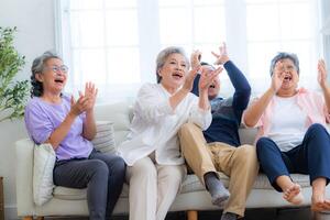 Happiness of the group females and male elderly sitting on the sofa. Senior people are talking and enjoy together at the living room. Joyful carefree retired senior friends enjoying relaxation. photo