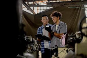 Men are inspecting steel parts for machine installation. team of teacher and student are learning to use heavy machines in steel factory. workers cooperate while doing quality control of manufactured. photo