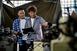 Men are inspecting steel parts for machine installation. team of teacher and student are learning to use heavy machines in steel factory. workers cooperate while doing quality control of manufactured. photo