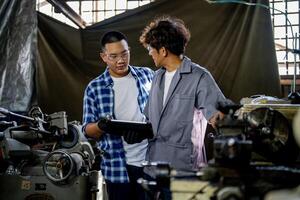 Men are inspecting steel parts for machine installation. team of teacher and student are learning to use heavy machines in steel factory. workers cooperate while doing quality control of manufactured. photo