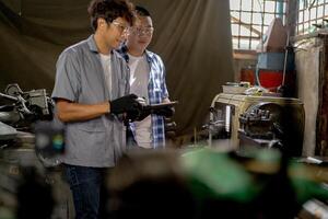 Men are inspecting steel parts for machine installation. team of teacher and student are learning to use heavy machines in steel factory. workers cooperate while doing quality control of manufactured. photo