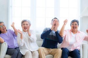 Happiness of the group females and male elderly sitting on the sofa. Senior people are talking and enjoy together at the living room. Joyful carefree retired senior friends enjoying relaxation. photo