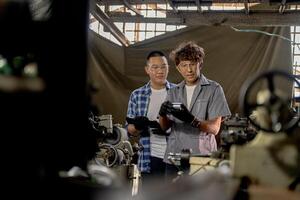 Men are inspecting steel parts for machine installation. team of teacher and student are learning to use heavy machines in steel factory. workers cooperate while doing quality control of manufactured. photo