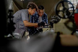 Men are inspecting steel parts for machine installation. team of teacher and student are learning to use heavy machines in steel factory. workers cooperate while doing quality control of manufactured. photo