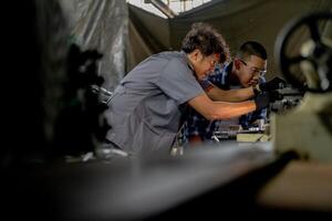 Men are inspecting steel parts for machine installation. team of teacher and student are learning to use heavy machines in steel factory. workers cooperate while doing quality control of manufactured. photo