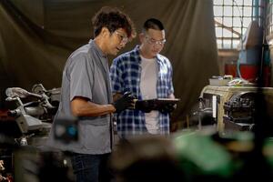 Men are inspecting steel parts for machine installation. team of teacher and student are learning to use heavy machines in steel factory. workers cooperate while doing quality control of manufactured. photo