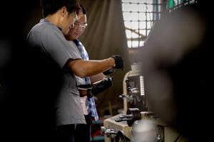 Men are inspecting steel parts for machine installation. team of teacher and student are learning to use heavy machines in steel factory. workers cooperate while doing quality control of manufactured. photo
