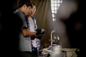 Men are inspecting steel parts for machine installation. team of teacher and student are learning to use heavy machines in steel factory. workers cooperate while doing quality control of manufactured. photo