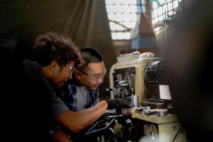 Men are inspecting steel parts for machine installation. team of teacher and student are learning to use heavy machines in steel factory. workers cooperate while doing quality control of manufactured. photo