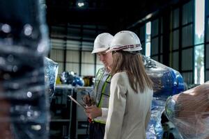 team engineers inspecting on machine with smart tablet. Worker works at heavy machine robot arm. The welding machine with a remote system in an industrial factory. Artificial intelligence concept. photo