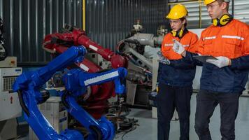 group of male engineer workers maintenance automatic robotic arm machine in a dark room factory. worker checking and repairing automatic robot hand machine. Worker wearing safety glasses and helmet. photo
