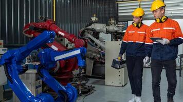 group of male engineer workers maintenance automatic robotic arm machine in a dark room factory. worker checking and repairing automatic robot hand machine. Worker wearing safety glasses and helmet. photo