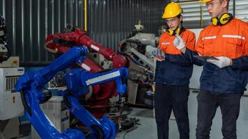 group of male engineer workers maintenance automatic robotic arm machine in a dark room factory. worker checking and repairing automatic robot hand machine. Worker wearing safety glasses and helmet. photo