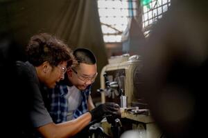 Men are inspecting steel parts for machine installation. team of teacher and student are learning to use heavy machines in steel factory. workers cooperate while doing quality control of manufactured. photo