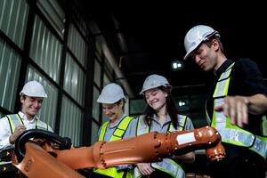 team engineers inspecting on machine with smart tablet. Worker works at heavy machine robot arm. The welding machine with a remote system in an industrial factory. Artificial intelligence concept. photo