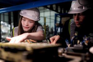 team engineers inspecting on machine with smart tablet. Worker works at heavy machine robot arm. The welding machine with a remote system in an industrial factory. Artificial intelligence concept. photo