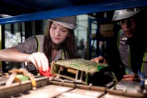 team engineers inspecting on machine with smart tablet. Worker works at heavy machine robot arm. The welding machine with a remote system in an industrial factory. Artificial intelligence concept. photo
