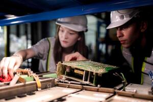 team engineers inspecting on machine with smart tablet. Worker works at heavy machine robot arm. The welding machine with a remote system in an industrial factory. Artificial intelligence concept. photo