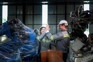 team engineers inspecting on machine with smart tablet. Worker works at heavy machine robot arm. The welding machine with a remote system in an industrial factory. Artificial intelligence concept. photo