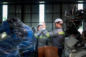 team engineers inspecting on machine with smart tablet. Worker works at heavy machine robot arm. The welding machine with a remote system in an industrial factory. Artificial intelligence concept. photo