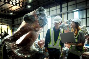 team engineers inspecting on machine with smart tablet. Worker works at heavy machine robot arm. The welding machine with a remote system in an industrial factory. Artificial intelligence concept. photo