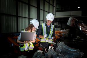 team engineers inspecting on machine with smart tablet. Worker works at heavy machine robot arm. The welding machine with a remote system in an industrial factory. Artificial intelligence concept. photo