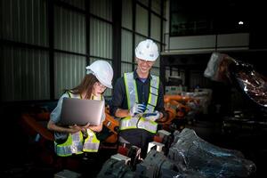 team engineers inspecting on machine with smart tablet. Worker works at heavy machine robot arm. The welding machine with a remote system in an industrial factory. Artificial intelligence concept. photo