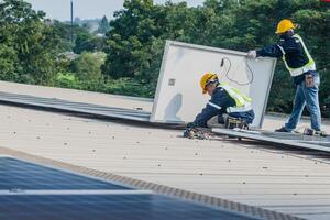 Worker Technicians are working to construct solar panels system on roof. Installing solar photovoltaic panel system. Men technicians carrying photovoltaic solar modules on roof. photo