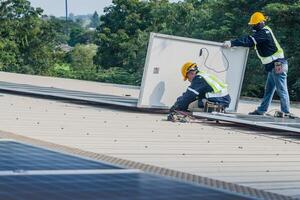 Worker Technicians are working to construct solar panels system on roof. Installing solar photovoltaic panel system. Men technicians carrying photovoltaic solar modules on roof. photo