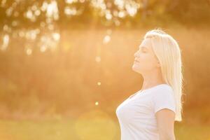 Closeup street portrait of a beautiful fashionable woman with long hair walking at sunset. Space for text. photo