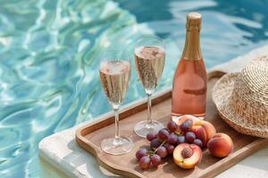 Sparkling wine served near the pool on a wooden tray with peaches and grapes photo