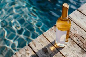 White wine bottle with white blank mock-up label with blue pool in the background photo